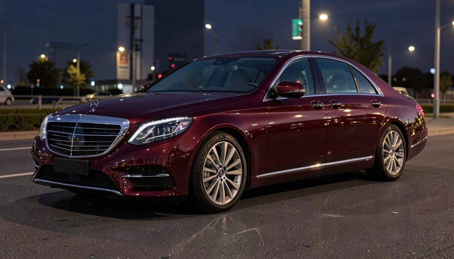 Deep burgundy Mercedes Benz S Class flagship sedan with long wheelbase, gleaming under evening lights