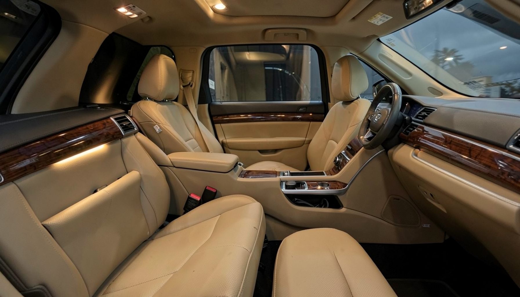 Spacious SUV interior with beige leather seats and wood trim accents, warm ambient lighting